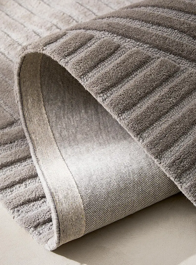 Corner fold detail of Arden Taupe hand tufted wool rug showing thickness texture and premium wool finish.