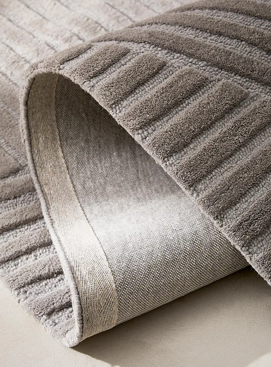 Corner fold detail of Arden Taupe hand tufted wool rug showing thickness texture and premium wool finish.