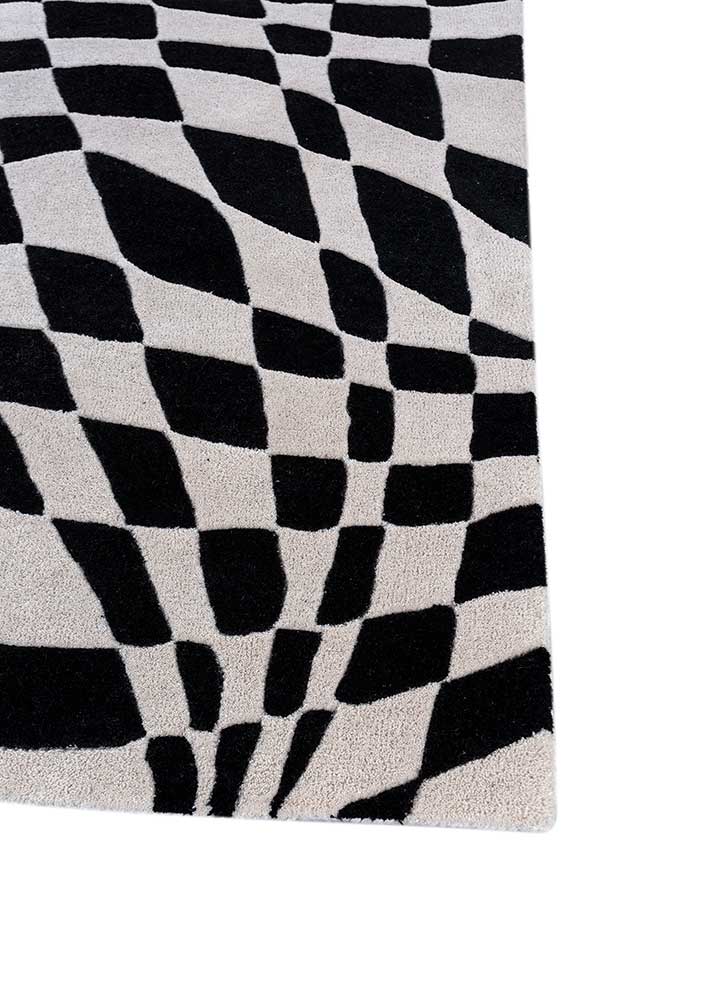 Corner close-up of Abstract Optical hand tufted wool rug showing edge binding.