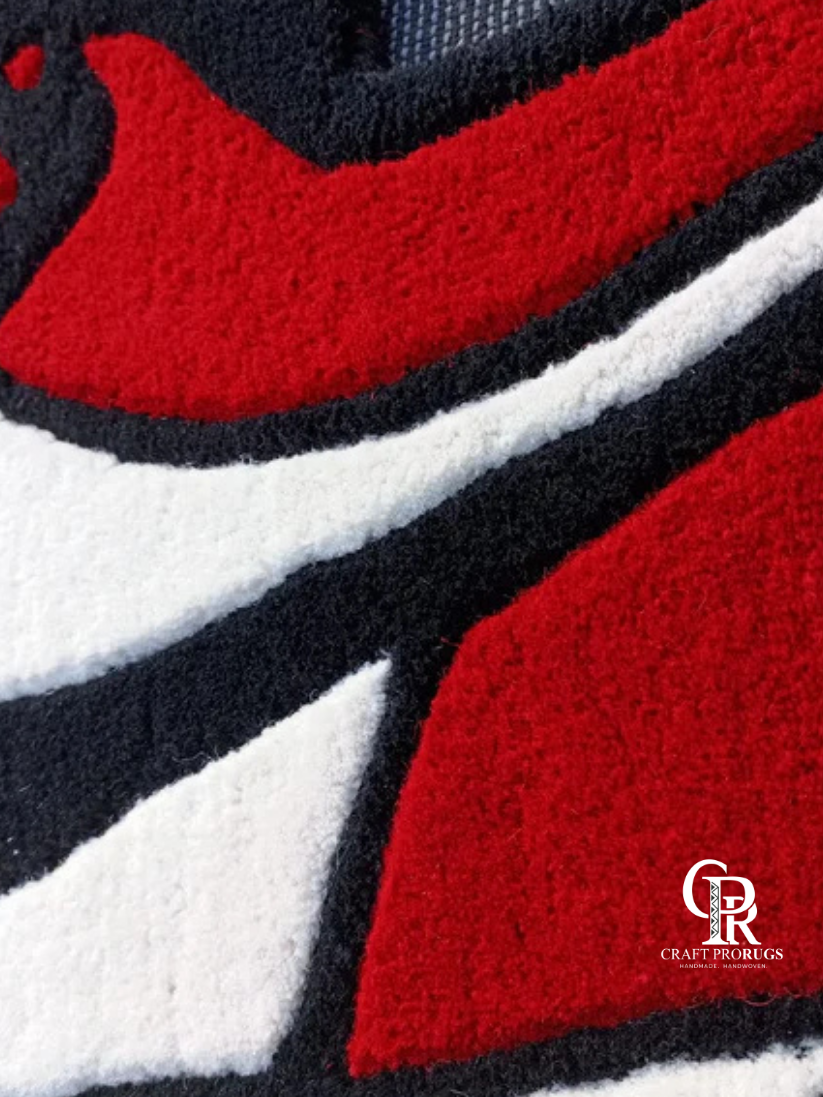 Close-up of Air Jordan Red Hand-Tufted Rug highlighting premium wool texture and detailed red and black sneaker pattern.