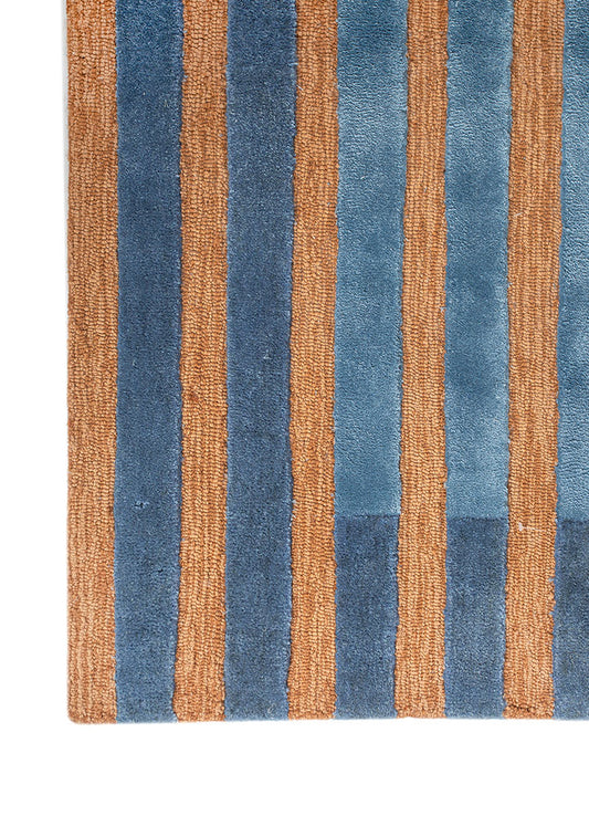 Full view of Blue Terra Stripe hand tufted wool rug featuring bold blue and rust stripes with modern geometric pattern.
