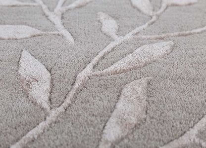 Close-up of botanical vine pattern on hand-tufted wool rug.