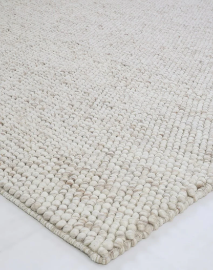 Corner detail of flatweave Nirvana Chalk Pebbles rug displaying slim profile, clean edges, and neat woven finish