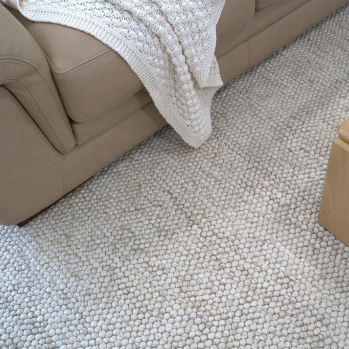 Flatweave Nirvana Chalk Pebbles rug styled under a sofa, showing chalk pebble pattern and how it anchors modern seating areas
