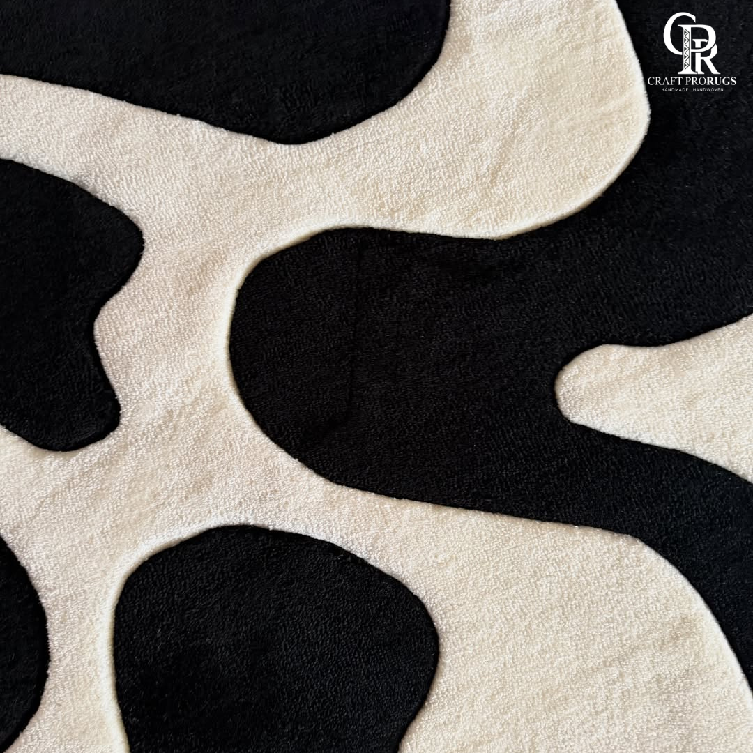 Close up view of monoloop hand tufted rug texture featuring black and white wave pattern