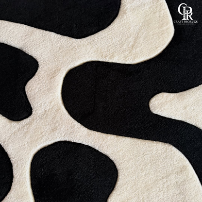 Close up view of monoloop hand tufted rug texture featuring black and white wave pattern
