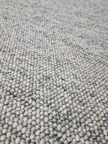 Macro close-up of pebble texture flatweave pure wool rug detailing looped wool yarns
