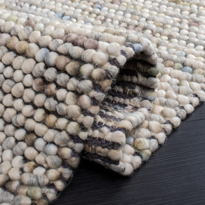 Close-up of Pebbles Multi Ivory flatweave rug showing looped wool and cotton texture, low-profile hand-woven design