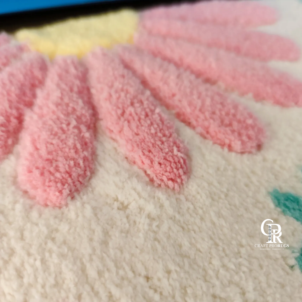 Detailed view of hand-tufted floral pattern on pink desk mat