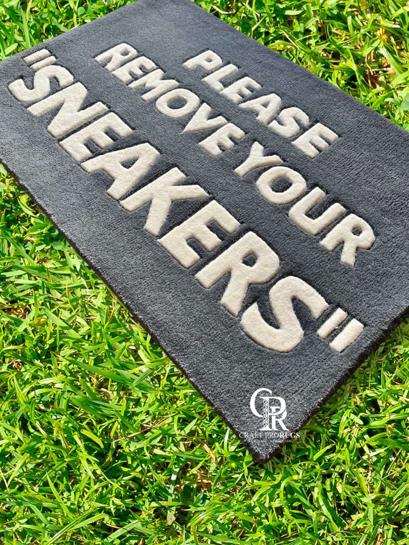 Hand-tufted Remove Sneakers Doormat angled view on green grass