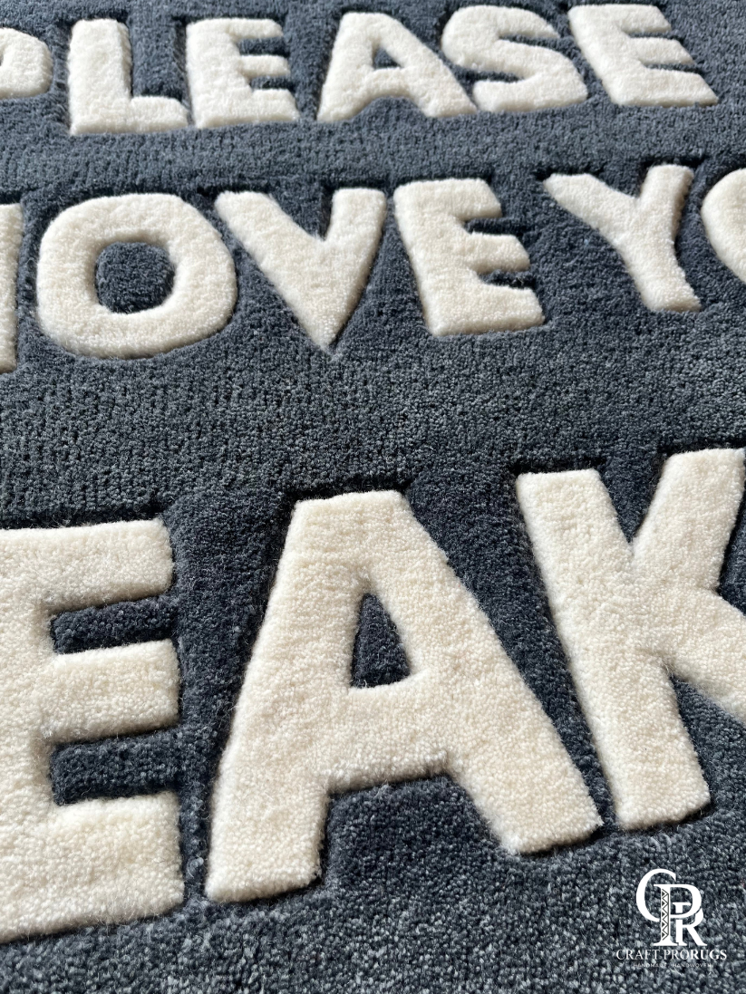 Close-up of hand-tufted text on Remove Sneakers Doormat