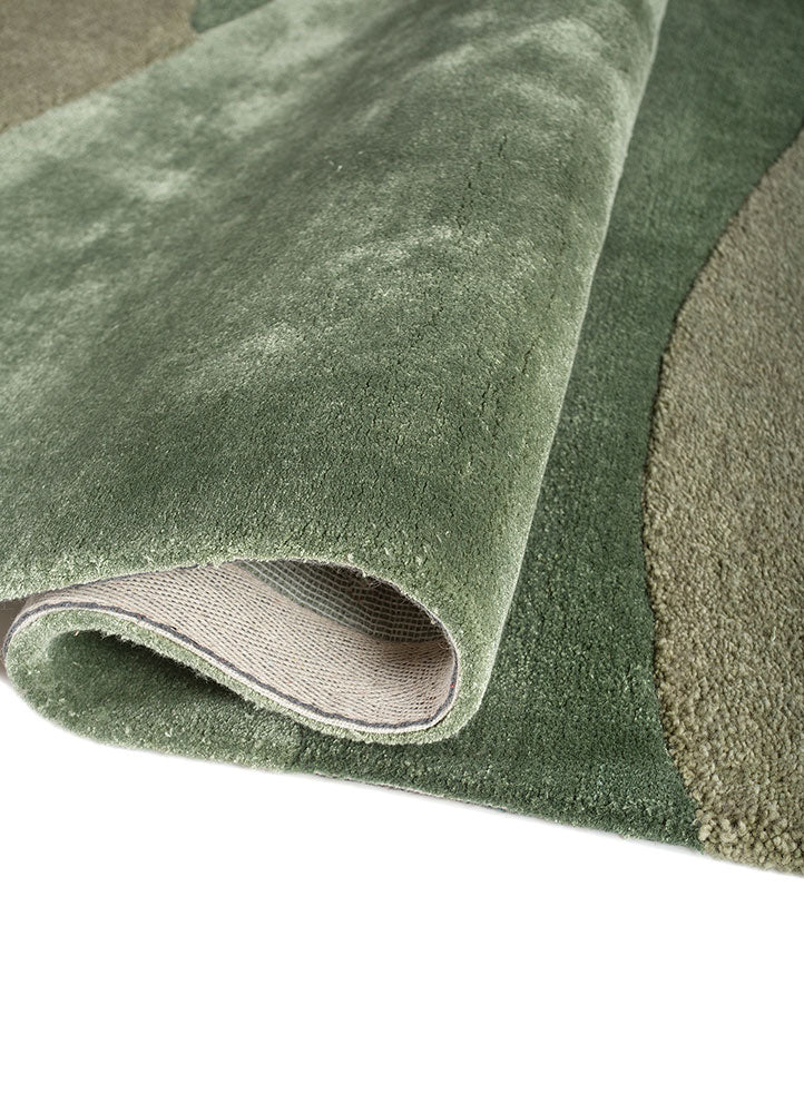 Rolled detail of Sage Horizon hand tufted wool rug showing smooth pile flexible structure and natural color blending.
