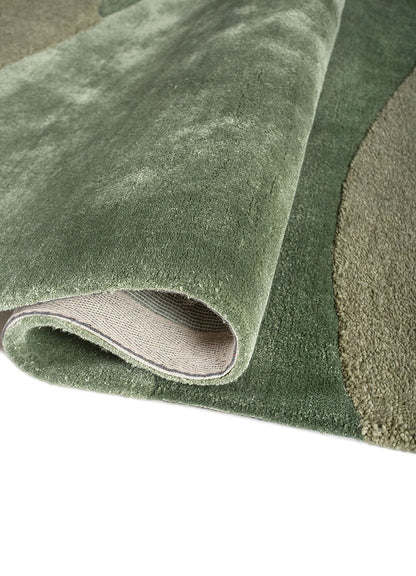 Rolled detail of Sage Horizon hand tufted wool rug showing smooth pile flexible structure and natural color blending.