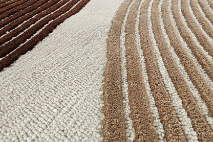 Corner detail of Sienna Wave hand tufted wool rug displaying curved wave lines and warm earthy color tones.
