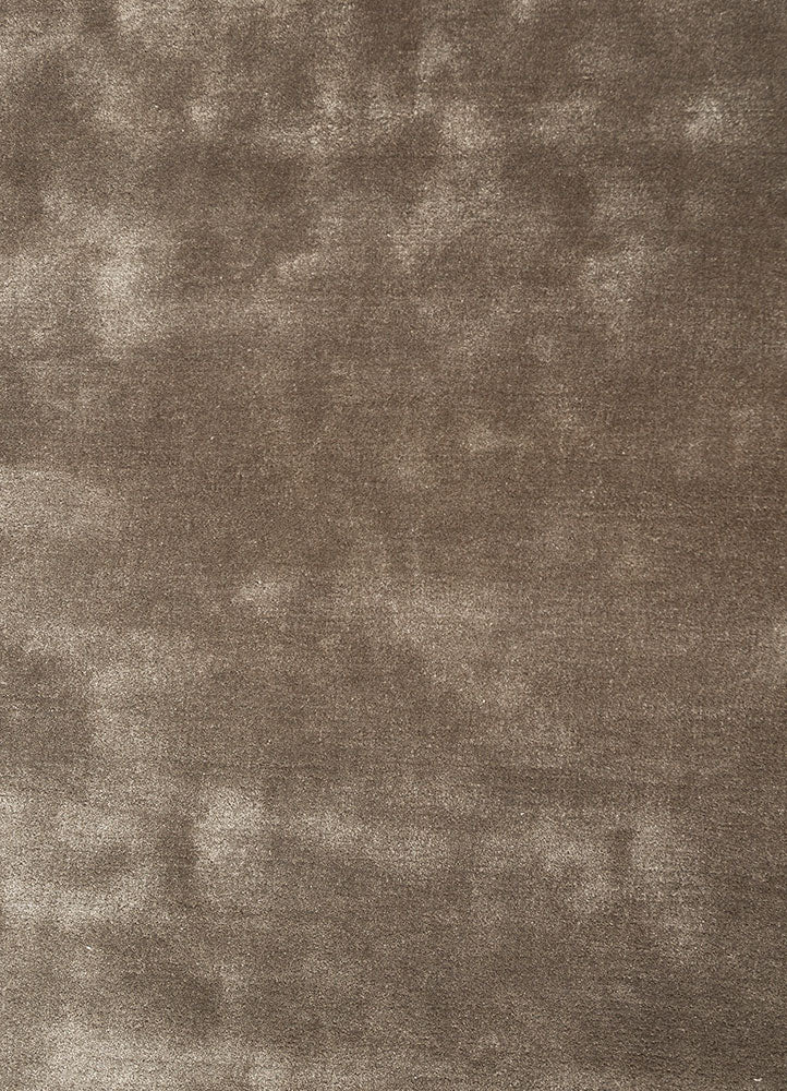 Close view of hand tufted wool rug highlighting smooth surface texture and rich taupe tone.