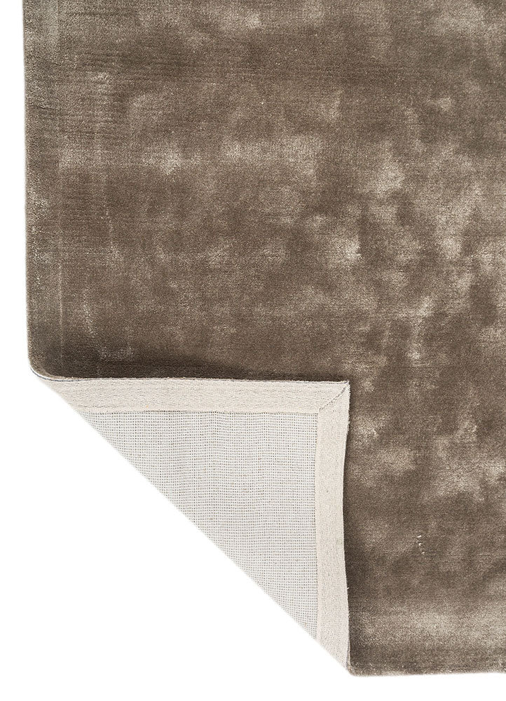 Corner view of hand tufted wool rug showing clean edges, smooth texture and refined taupe color.