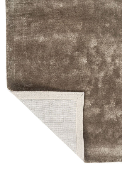 Corner view of hand tufted wool rug showing clean edges, smooth texture and refined taupe color.