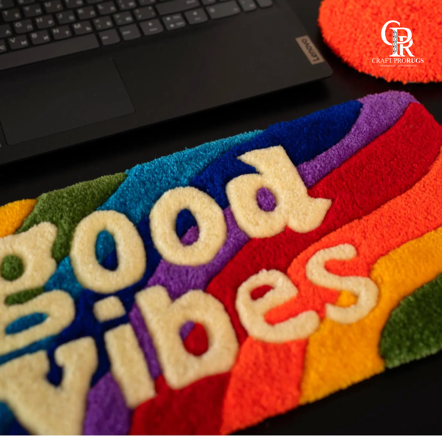 lose view of Vibe Stripe Keyboard Rug showing handmade tufted surface with vibrant rainbow colors and clear lettering”